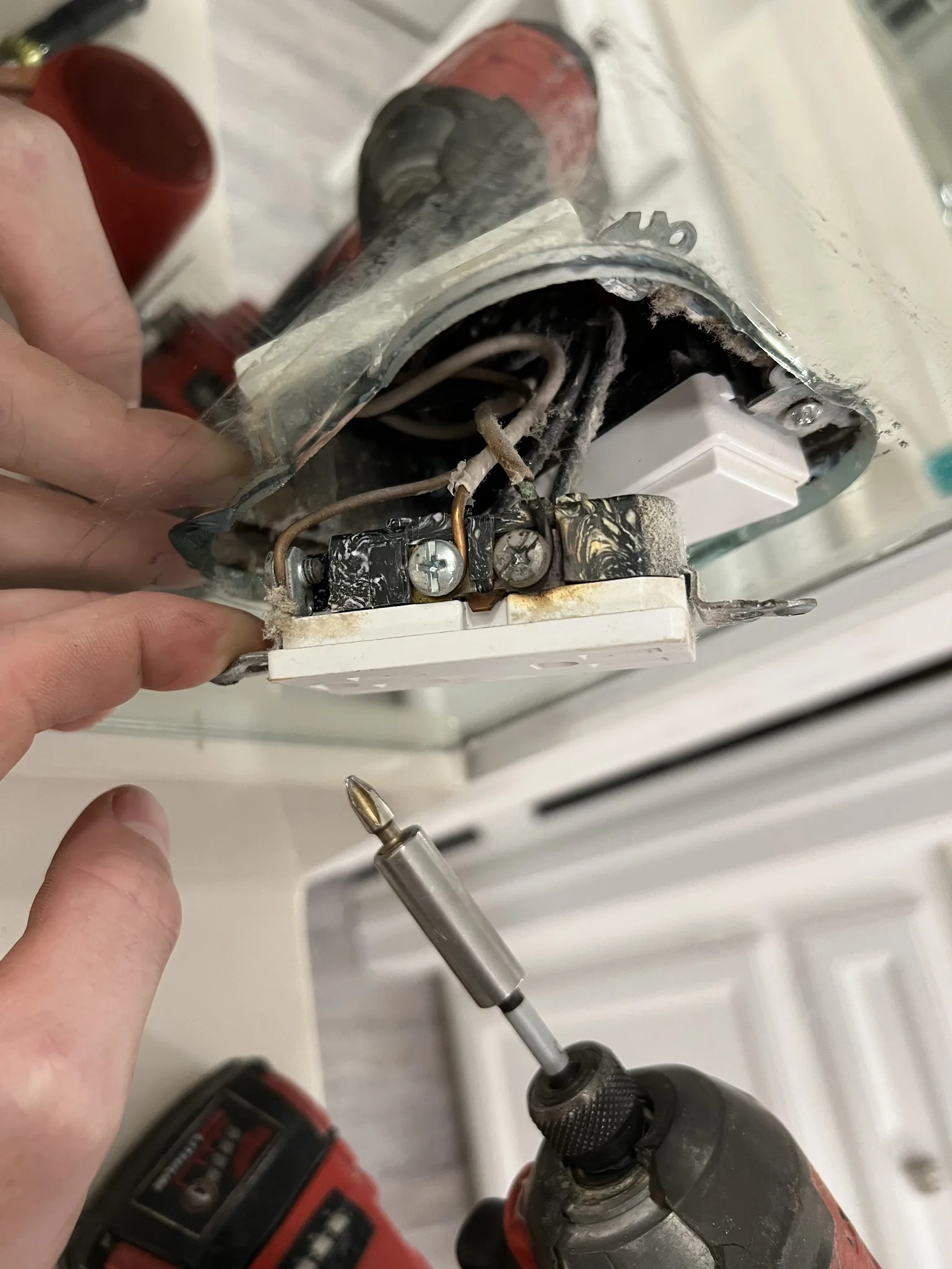Opened wall switch or electrical device showing damaged terminal area