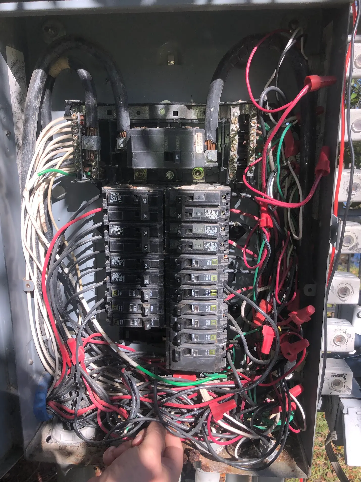 Messy electrical panel with crowded wiring and poorly organized circuits
