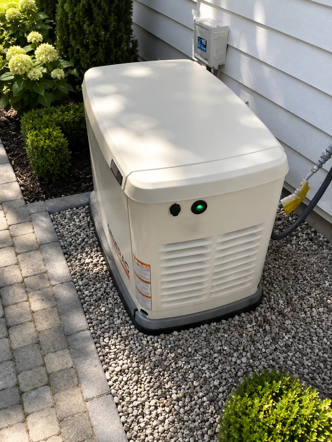 Residential standby power unit installed beside a home with transfer switch equipment