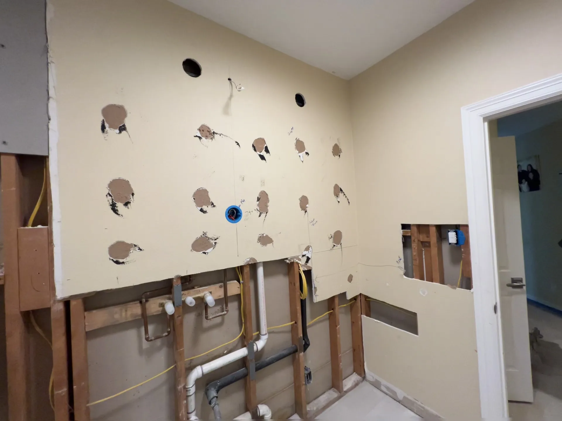 Bathroom vanity wall opened during remodel with electrical rough-in visible.