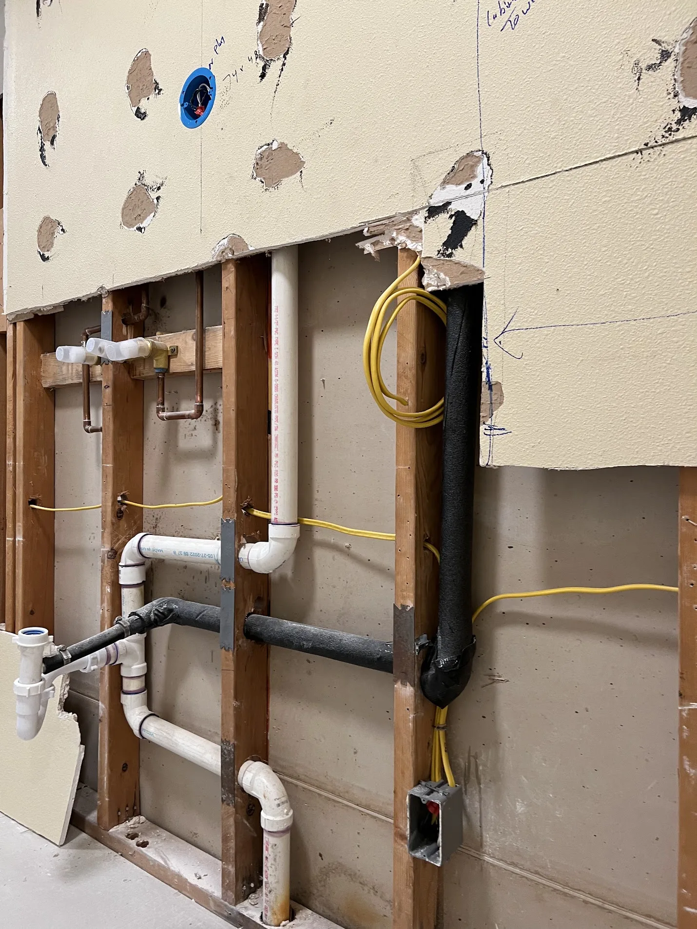 Bathroom remodel in progress with wall opened for electrical work and finishing.