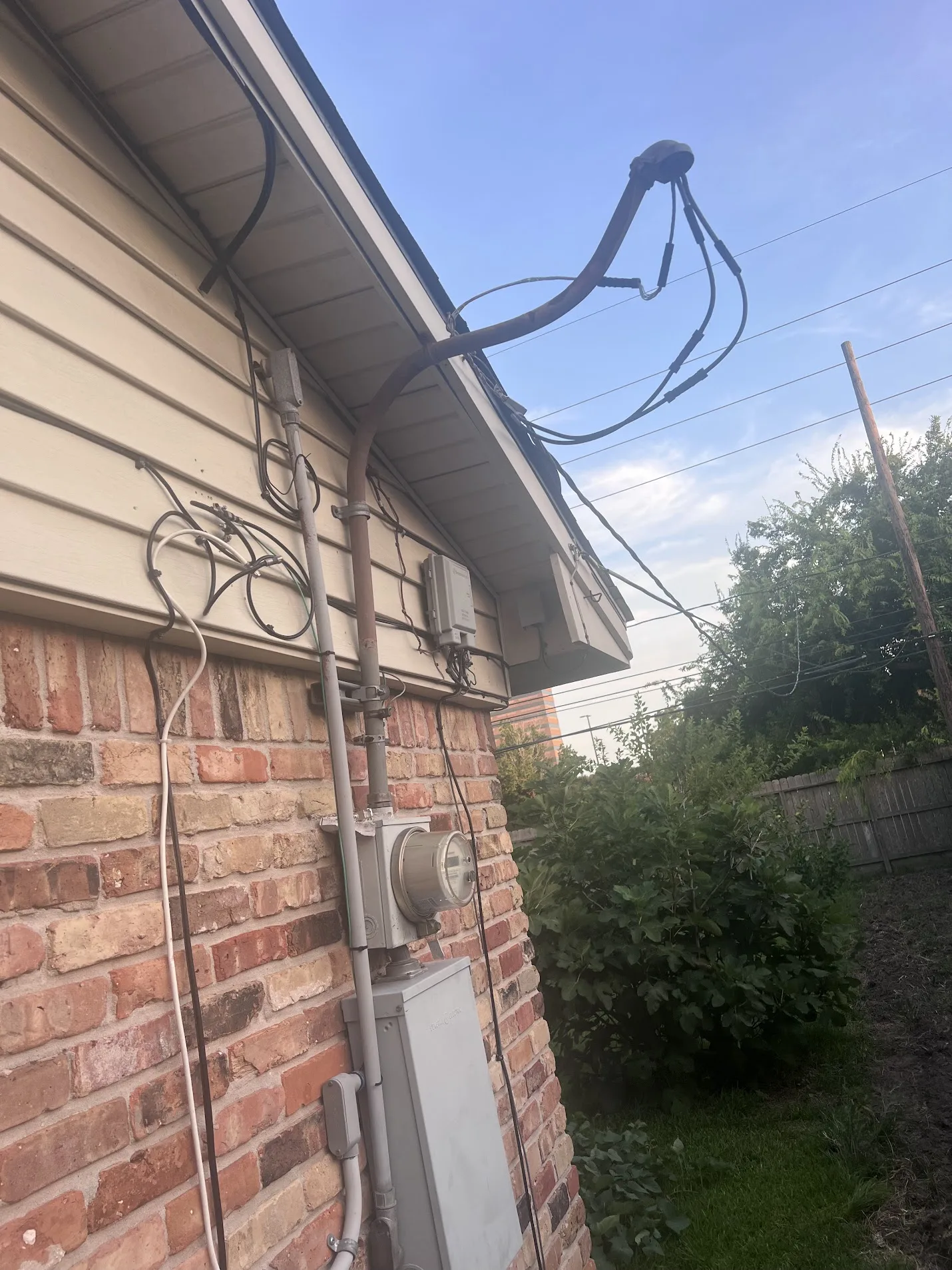 Close-up of completed overhead electrical service routing on a home exterior.