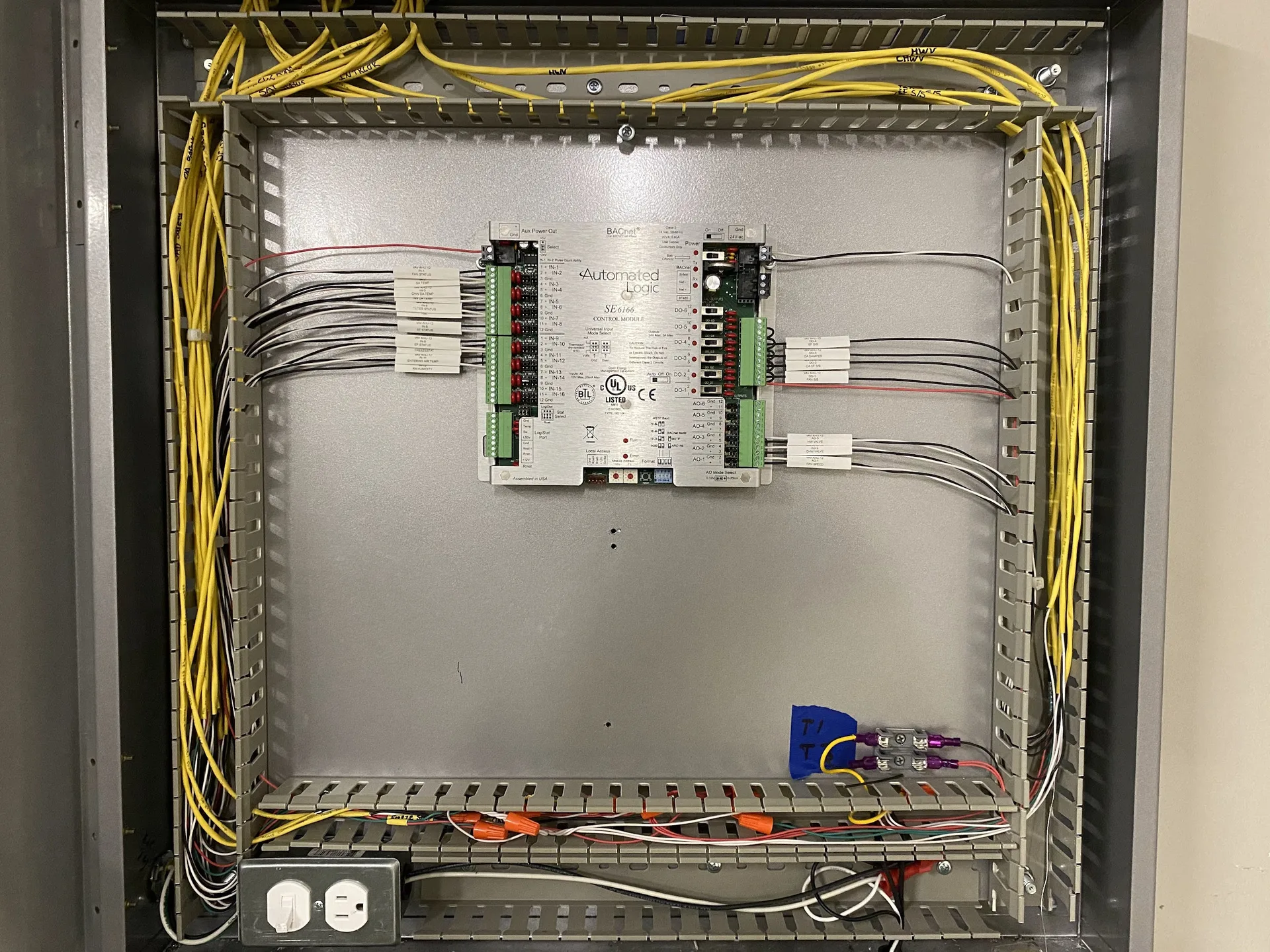 Structured wiring panel with low-voltage equipment and organized cabling.