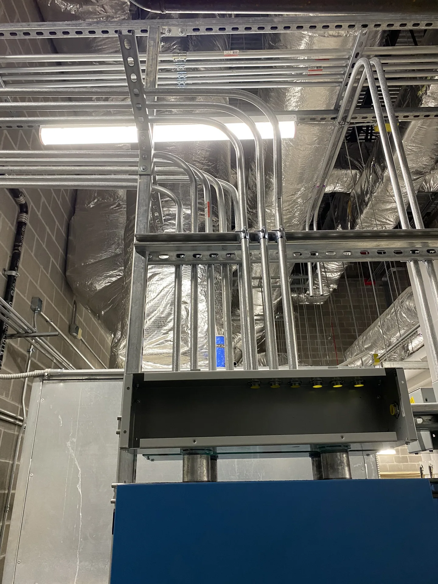 Overhead conduit installation inside a commercial building.