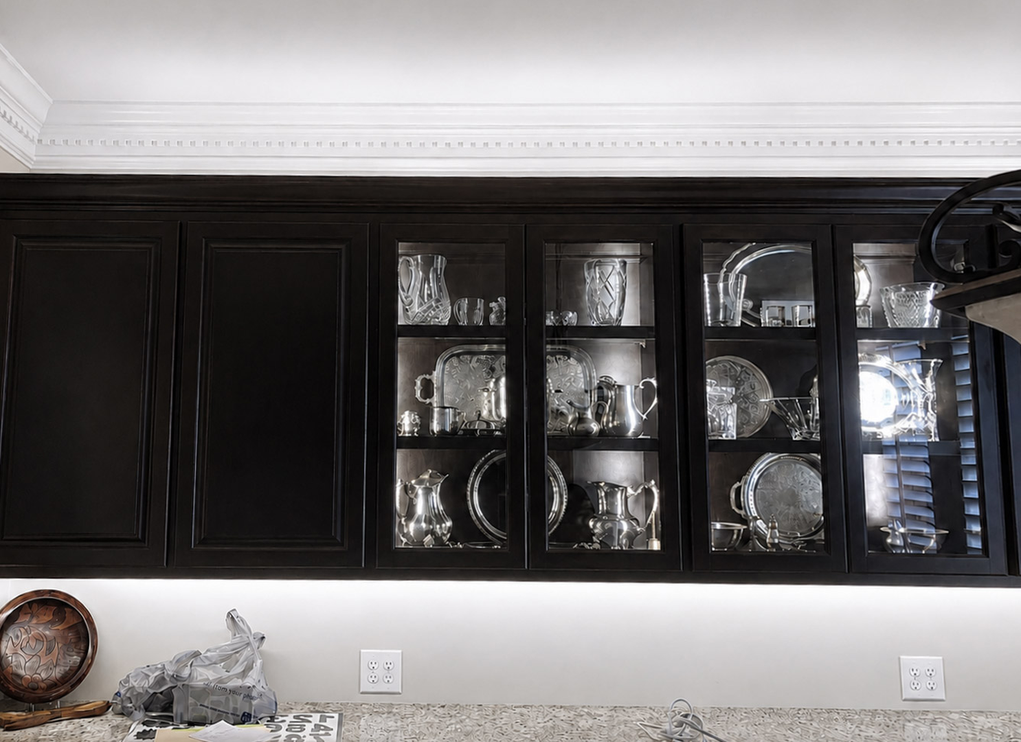 Lighted display cabinet with shelving and glass-front detail.