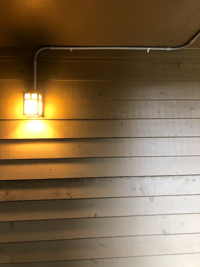 Residential exterior light fixture mounted beside a doorway.