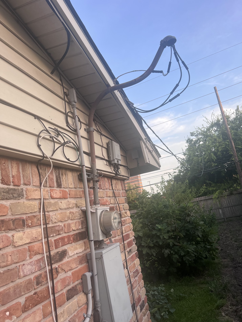 Weatherhead, service mast, overhead conductors and electrical meter on a Houston-area property